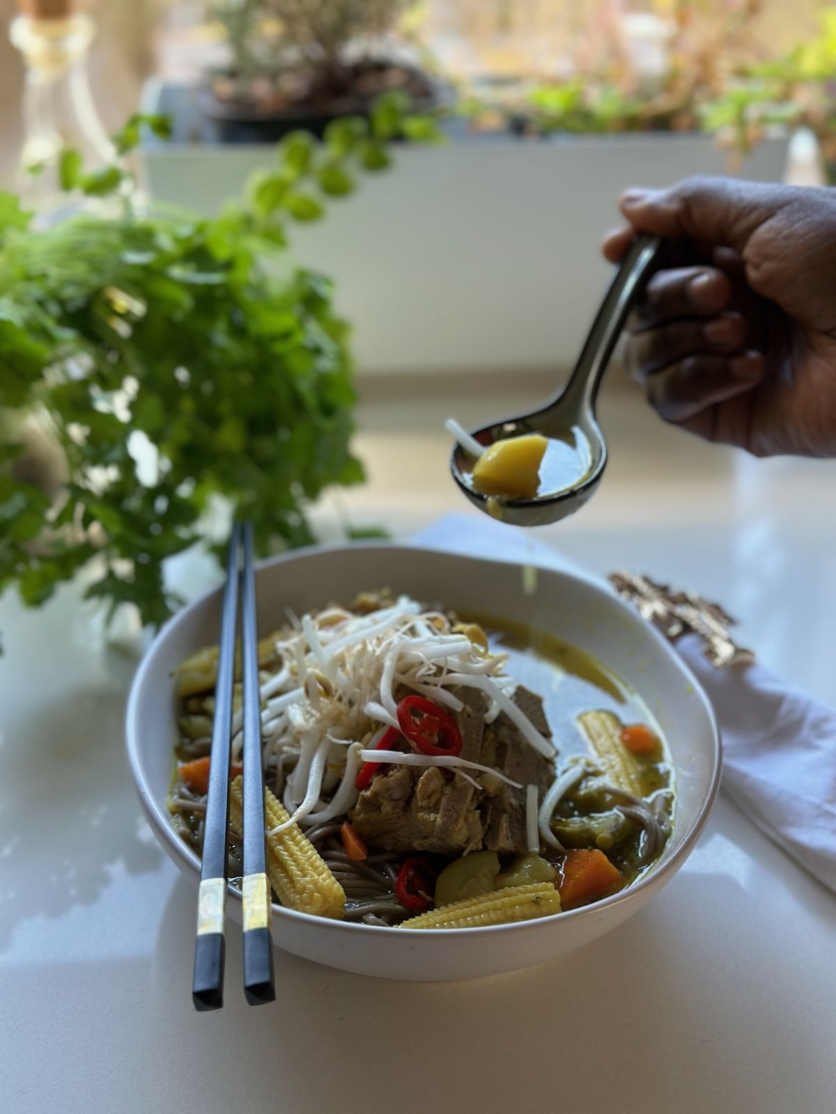 Nourishing noodle soup made with chicken broth, fresh vegetables, and tender pork slices, served steaming hot in a deep ceramic bowl.