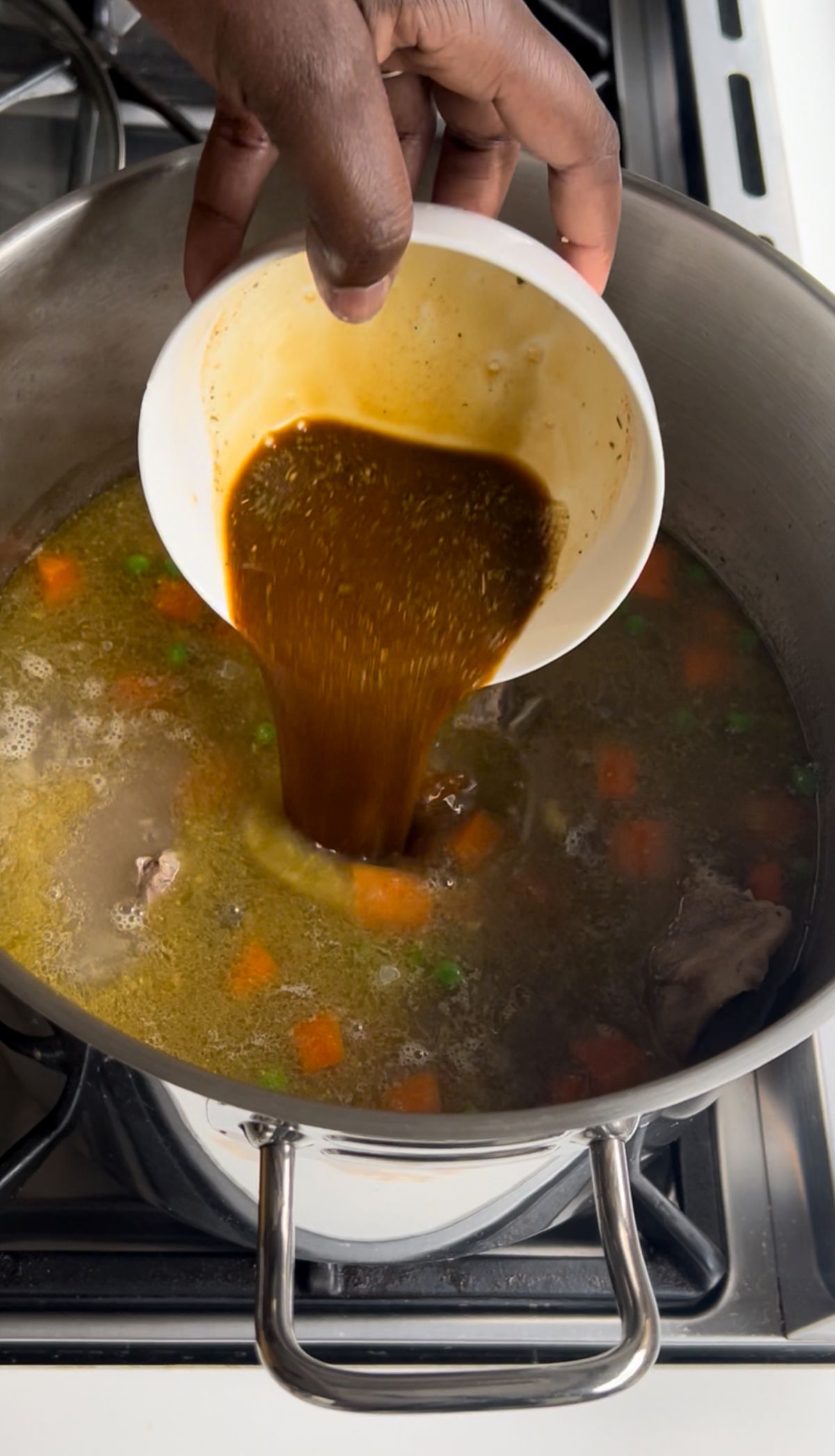 Red miso paste and cooking wine being whisked together in a small bowl to create a flavourful base.
